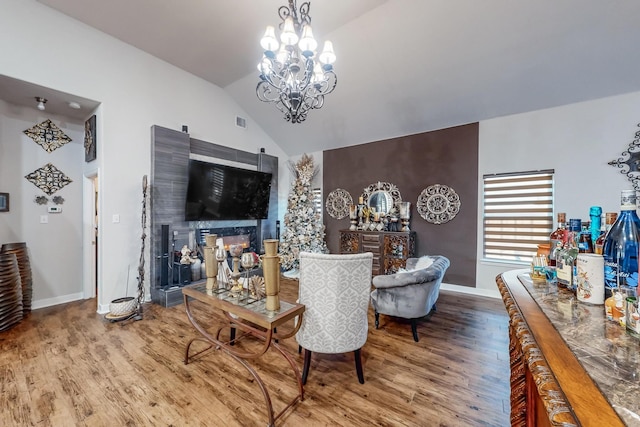 living room featuring hardwood / wood-style floors, lofted ceiling, and a notable chandelier