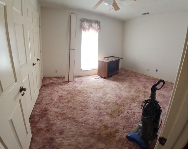 carpeted spare room with ceiling fan