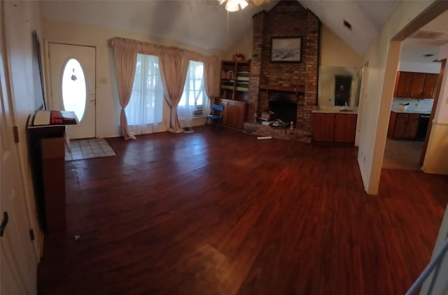 unfurnished living room featuring a brick fireplace, dark hardwood / wood-style flooring, and lofted ceiling