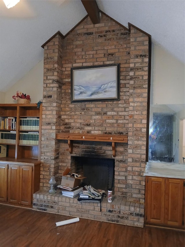 unfurnished living room featuring a brick fireplace, dark hardwood / wood-style flooring, and vaulted ceiling with beams