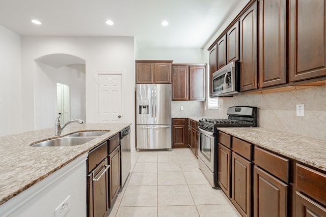 kitchen featuring light stone counters, light tile patterned floors, sink, and appliances with stainless steel finishes