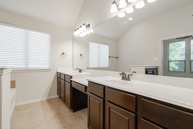 bathroom with a bath, vanity, tile patterned floors, and lofted ceiling