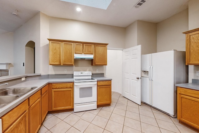 kitchen featuring white appliances, light tile patterned flooring, and sink