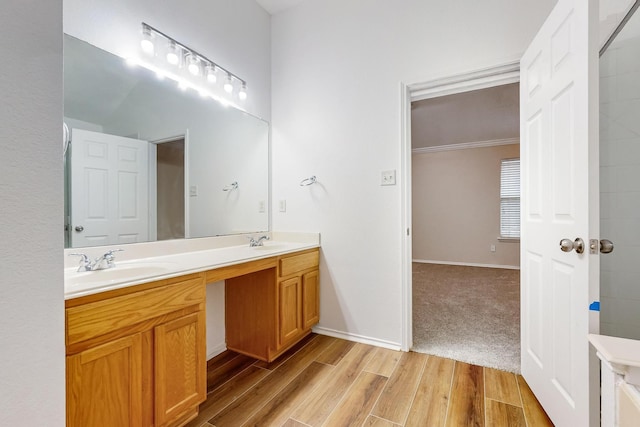 bathroom with crown molding, vanity, and wood-type flooring