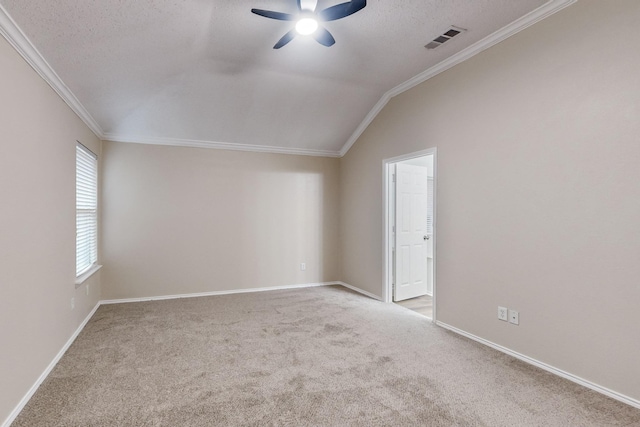 carpeted spare room with ceiling fan, ornamental molding, vaulted ceiling, and a textured ceiling