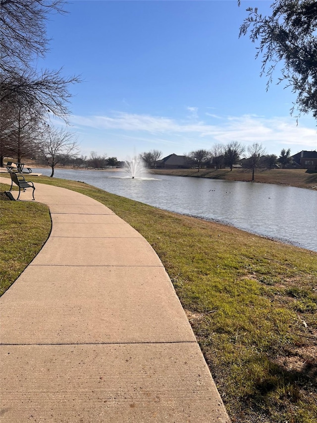 view of community with a yard and a water view