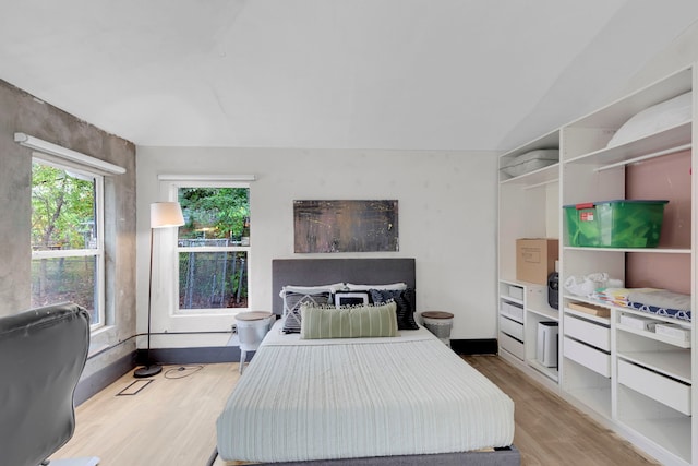 bedroom featuring vaulted ceiling and light wood-type flooring