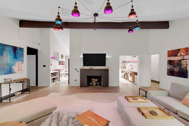 living room with beamed ceiling, high vaulted ceiling, and light hardwood / wood-style flooring