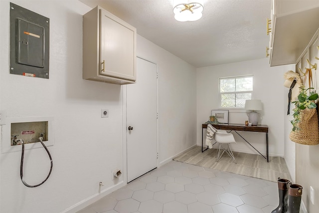 laundry area with electric panel, hookup for an electric dryer, washer hookup, a textured ceiling, and cabinets