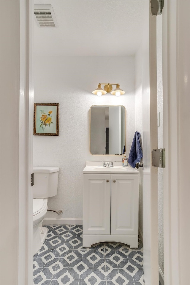 bathroom with tile patterned flooring, vanity, and toilet