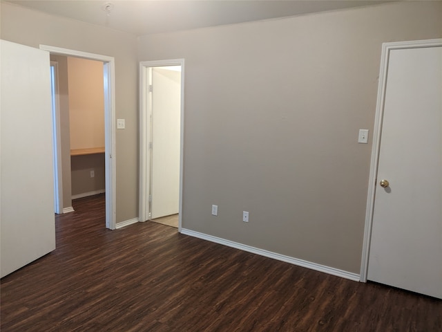 unfurnished room with dark wood-type flooring