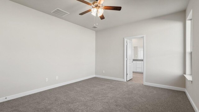 empty room with ceiling fan, light hardwood / wood-style floors, and a tray ceiling