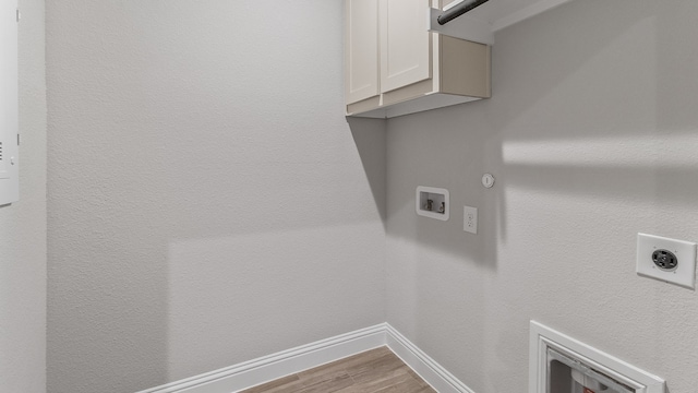 clothes washing area featuring light hardwood / wood-style floors, hookup for an electric dryer, washer hookup, cabinets, and gas dryer hookup