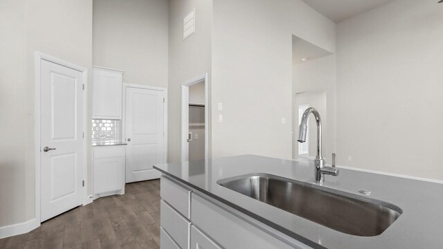 kitchen featuring white cabinetry, light hardwood / wood-style flooring, appliances with stainless steel finishes, backsplash, and light stone counters