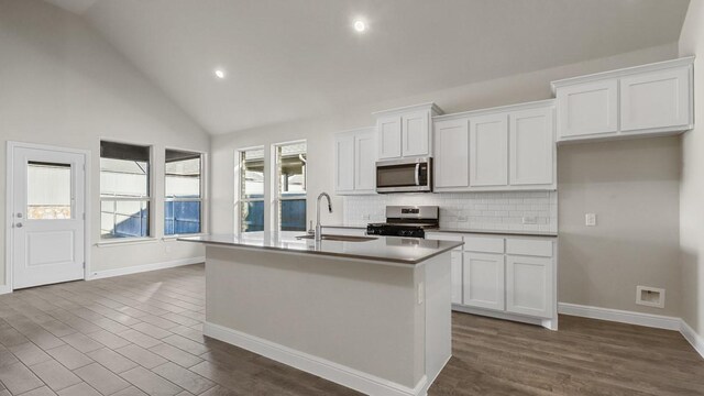 kitchen featuring white cabinetry, ceiling fan, sink, a kitchen island with sink, and high vaulted ceiling