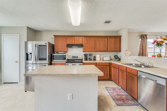 kitchen with sink, light hardwood / wood-style floors, a textured ceiling, and appliances with stainless steel finishes