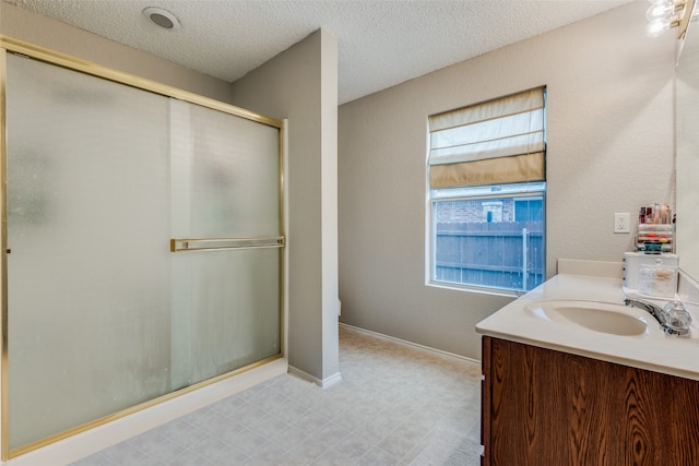 bathroom with plenty of natural light, a textured ceiling, and walk in shower