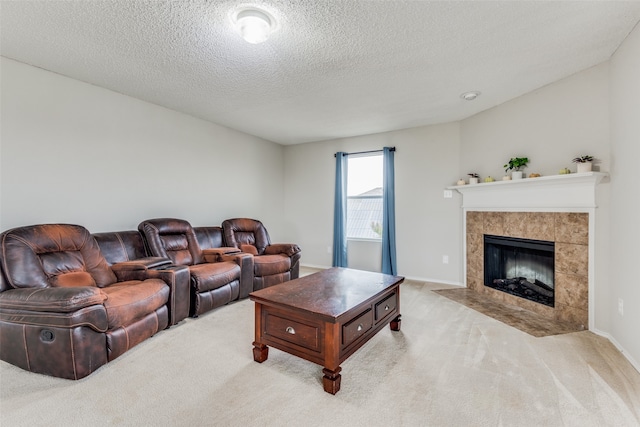 living room with a tile fireplace, a textured ceiling, and light colored carpet