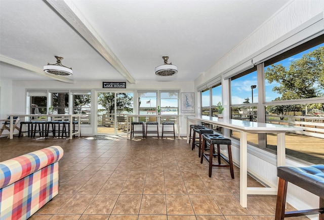 sunroom featuring beam ceiling