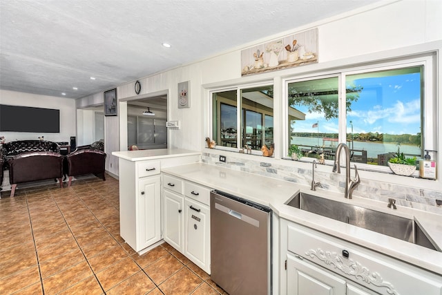 kitchen with dishwasher, white cabinetry, a water view, and plenty of natural light