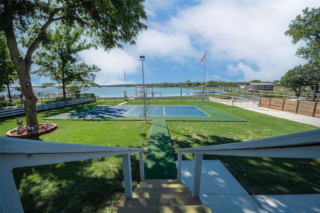 view of home's community featuring a water view, tennis court, and a yard