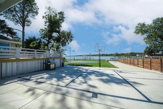 view of patio featuring a grill, a water view, and basketball court