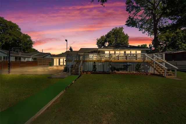 yard at dusk featuring a wooden deck and a patio