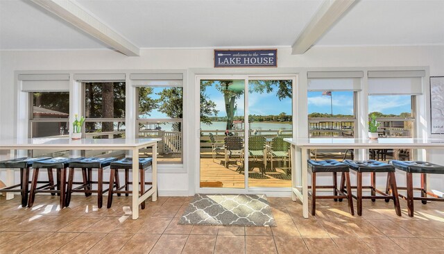 sunroom featuring beam ceiling