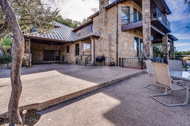 1133 Brackeen Dr, Graford, TX 76449 - rear view of property with stone siding, a balcony, a patio, a standing seam roof, and metal roof