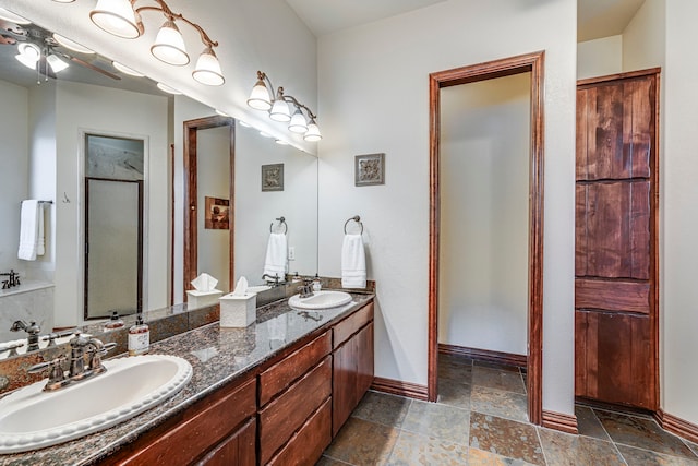 1133 Brackeen Dr, Graford, TX 76449 - full bath with baseboards, double vanity, a ceiling fan, and stone tile flooring