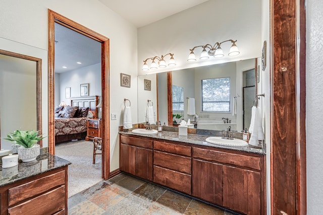 1133 Brackeen Dr, Graford, TX 76449 - ensuite bathroom featuring double vanity, a tub to relax in, and stone tile floors
