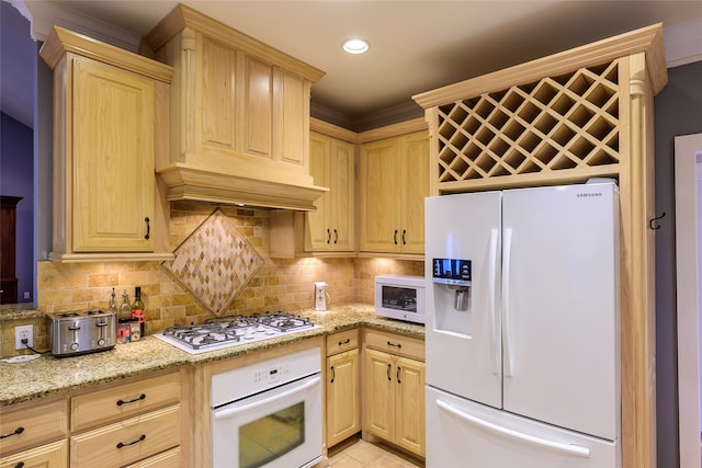 kitchen with light stone counters, light brown cabinetry, white appliances, and backsplash