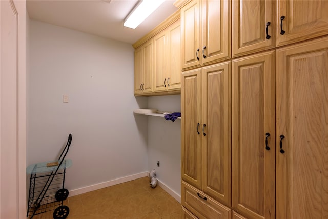 laundry room featuring cabinets and light tile patterned floors