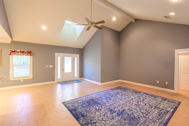 foyer with ceiling fan, beam ceiling, a skylight, and high vaulted ceiling