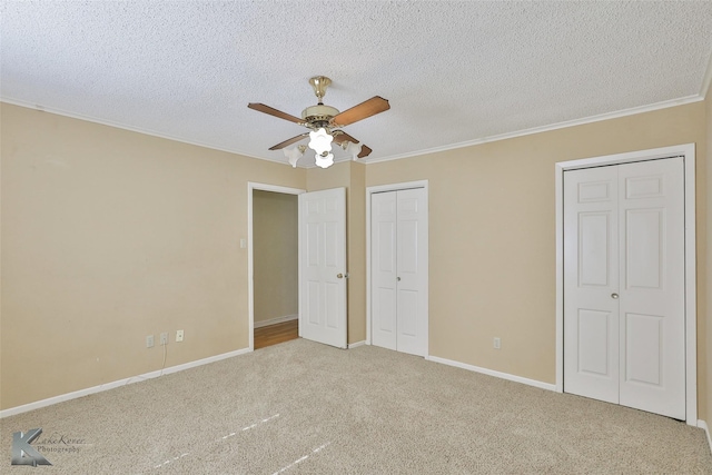 unfurnished bedroom with ceiling fan, carpet floors, a textured ceiling, and ornamental molding