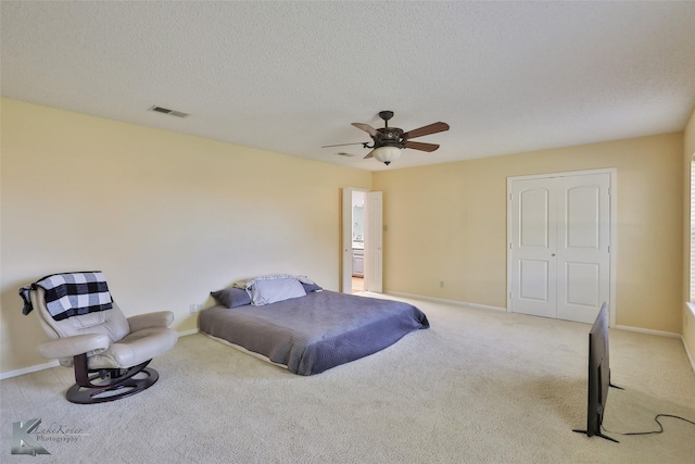 bedroom with light carpet, a textured ceiling, a closet, and ceiling fan