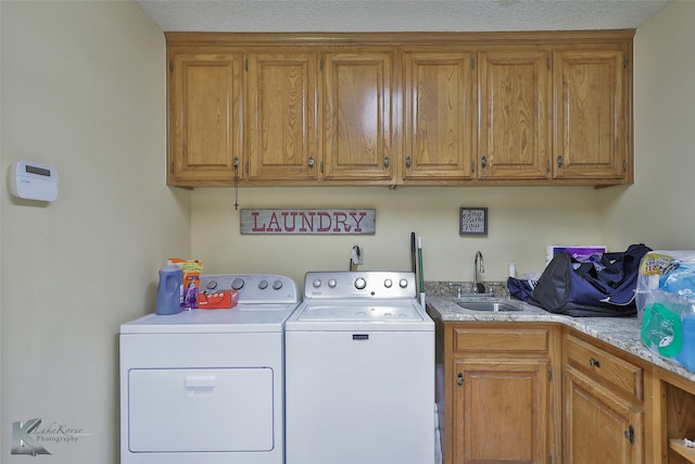 laundry room with cabinets, washing machine and dryer, and sink