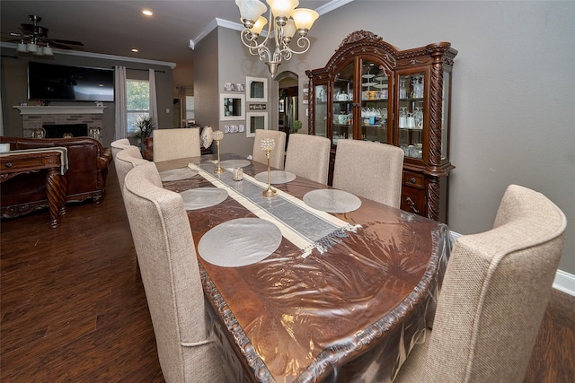 dining area with dark hardwood / wood-style floors, crown molding, and ceiling fan with notable chandelier