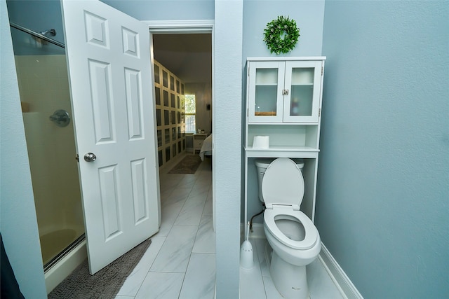 bathroom with toilet and a shower with door