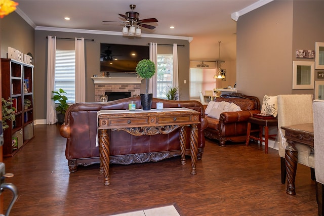 bedroom featuring a fireplace, crown molding, dark hardwood / wood-style flooring, and ceiling fan