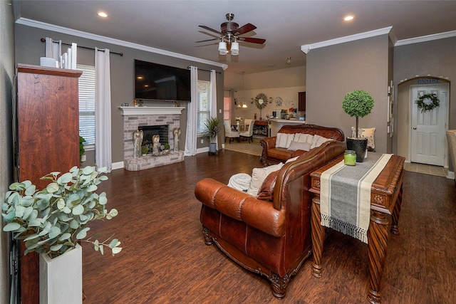 living room featuring ceiling fan, dark hardwood / wood-style flooring, ornamental molding, and a fireplace