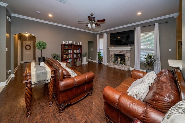 living room with a fireplace, ceiling fan, ornamental molding, and dark wood-type flooring