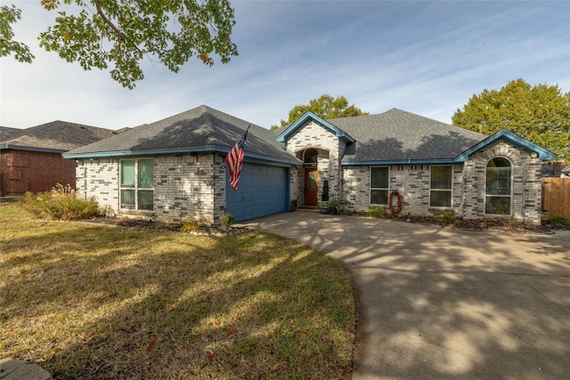 ranch-style home featuring a front lawn and a garage