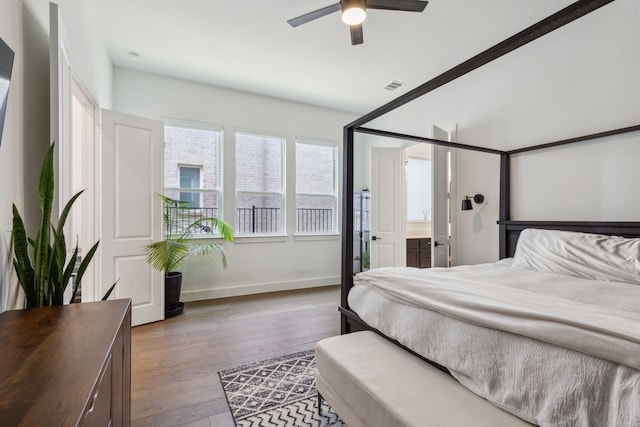 bedroom with hardwood / wood-style flooring, ensuite bath, and ceiling fan