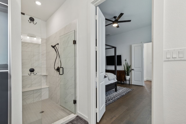 bathroom featuring ceiling fan, a shower with door, and wood-type flooring