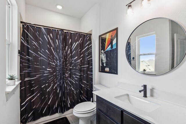 bathroom with tile patterned floors, vanity, toilet, and walk in shower