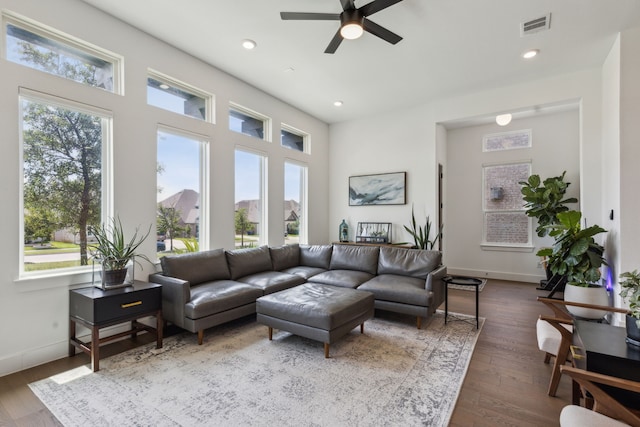 living room with dark hardwood / wood-style floors, ceiling fan, and a healthy amount of sunlight