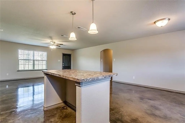 kitchen featuring decorative light fixtures, ceiling fan, and a center island