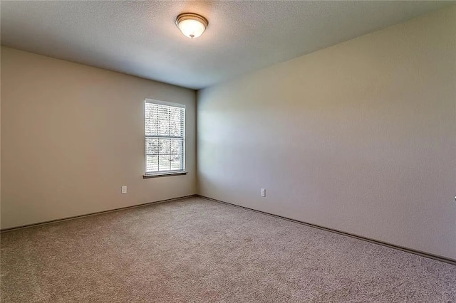 carpeted spare room featuring a textured ceiling