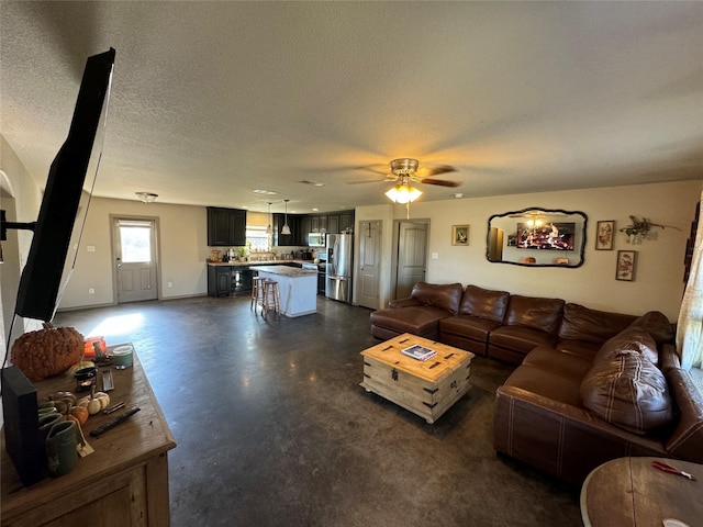 living room featuring a textured ceiling and ceiling fan